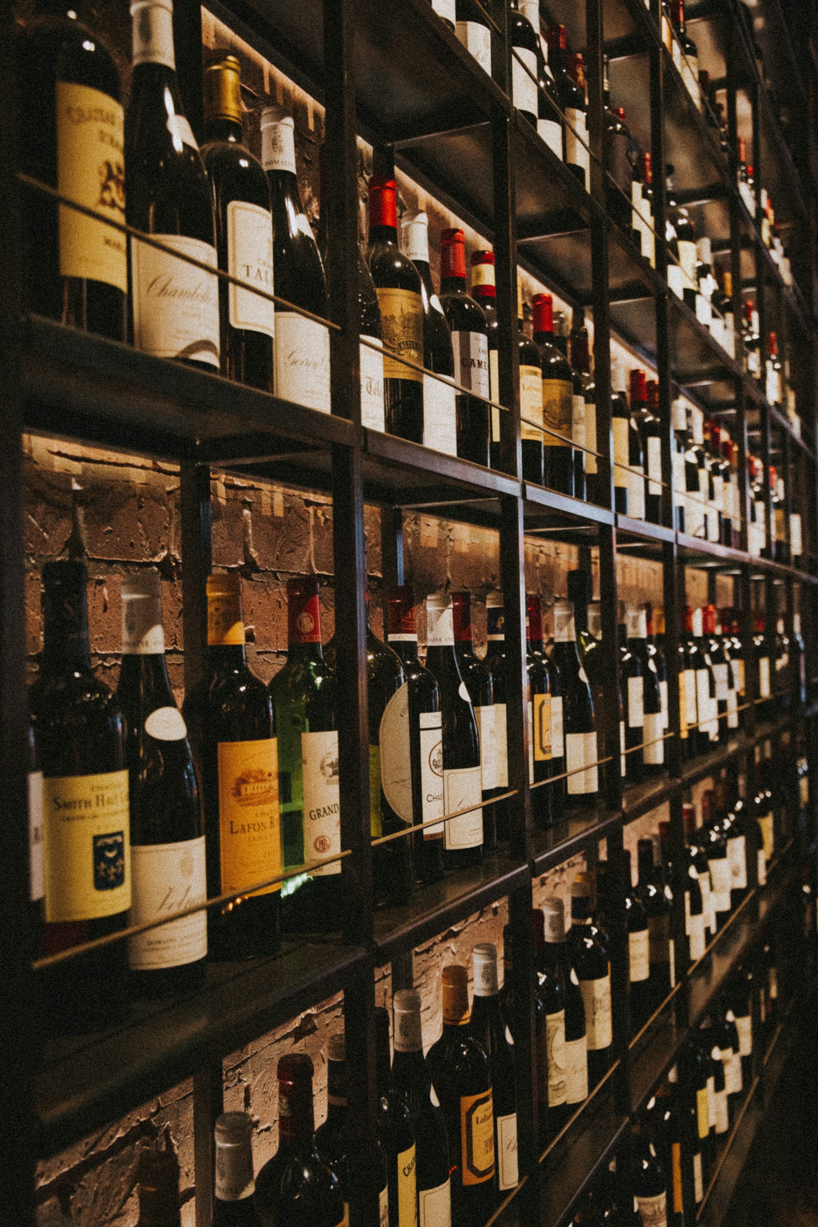 Illustrative collection of wine bottles on wooden shelves